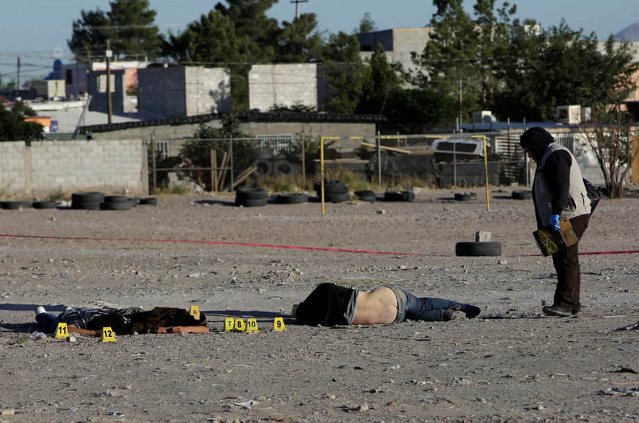 A forensic investigator at a crime scene where three men were killed by unknown assailants in Ciudad Juarez, Mexico, May 18, 2017.