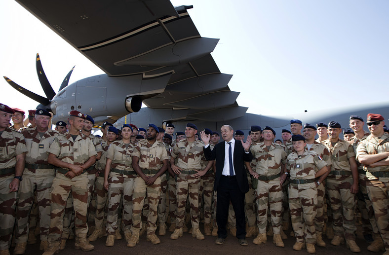 Minister obrony Francji Jean-Yves Le Drian (w środku w garniturze) pozuje z francuskimi żołnierzami przed wojskowym samolotem transportowym w Gao we wschodnim Mali, 31 grudnia 2013 r.