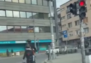 Muškarac na biciklu prolazi kroz crveno