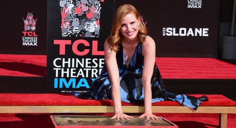 Actress Jessica Chastain smiles while imprinting her handprints in the block of cement at the TCL Chinese Theater in Hollywood, California on November 3, 2016