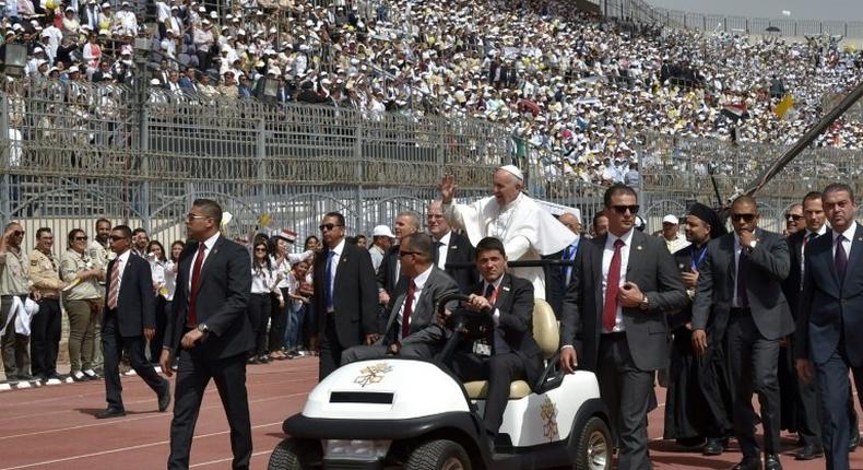 Pope Francis is surrounded by security before the start of a mass on April 29, 2017 at a stadium in Cairo