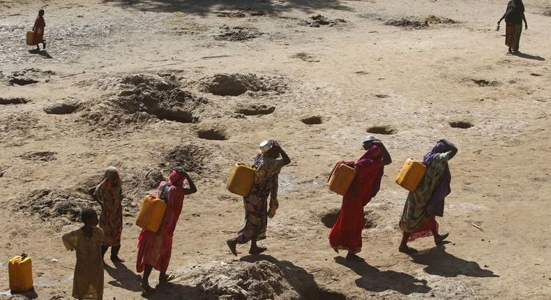 Women carry jerry cans of water from shallow wells dug from the sand along the Shabelle River bed, which is dry due to drought in Somalia's Shabelle region, March 19, 2016. REUTERS/Feisal Omar