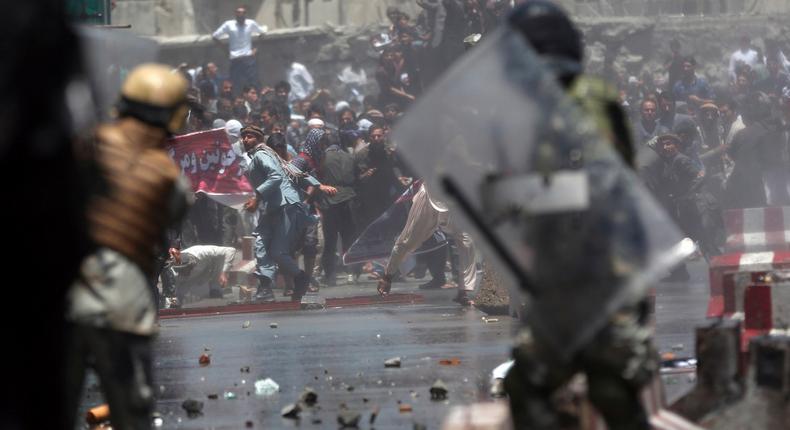 Protesters throwing stones toward security forces during a demonstration in Kabul, Afghanistan.