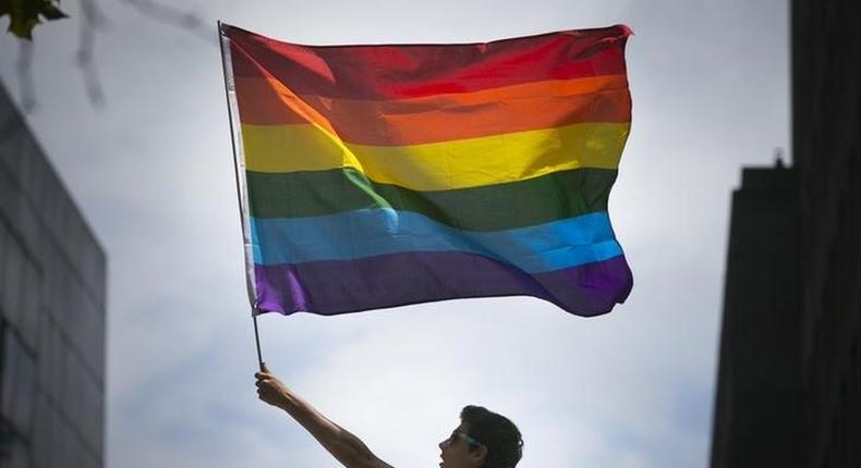 A man waves a rainbow flag while observing a gay pride parade in San Francisco, California June 28, 2015. REUTERS/Elijah Nouvelage