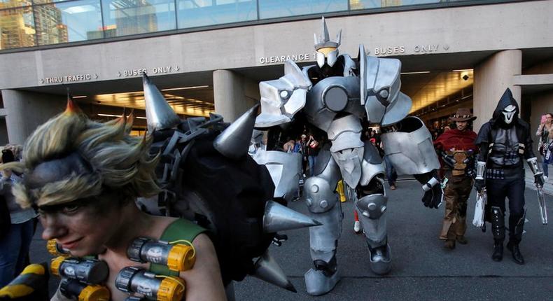 A man in a dressed as Reinhardt from Overwatch walks with other attendees at New York Comic Con in Manhattan