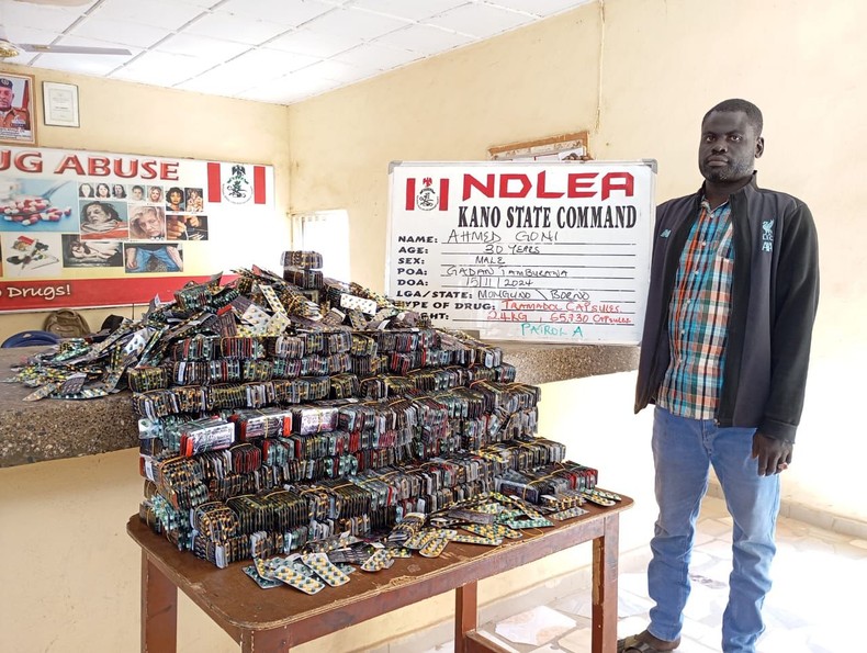 A suspect pictured with illicit drugs intercepted by NDLEA