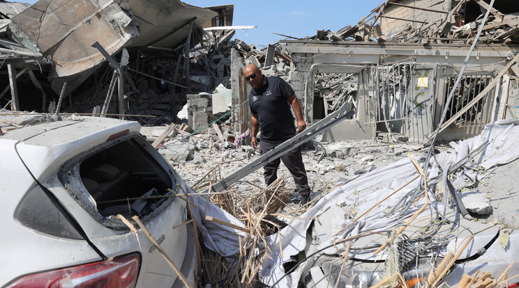 Rendőr vizsgálja a romokat egy palesztin rakétatámadást követően Tel-Avivban 2023. október 8-án. Előző nap a Hamász palesztin iszlamista szervezet rakétaáradatot zúdított Izrael déli és középső részére a Gázai övezetből, és több tucat fegyverese hatolt be izraeli településekre. Az izraeli egészségügyi tárca október 8-i közlése szerint 2048 sebesültet szállítottak kórházba, akik közül az életveszélyes és súlyos sebesültek számát háromszázötvenre becsülik / Fotó: MTI/EPA/Abir Szultan