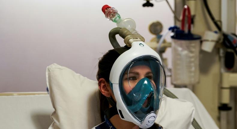 A medical worker tests a Decathlon snorkeling mask, with a 3D-printed respiratory valve fitting attached, at the Erasme Hospital in Brussels