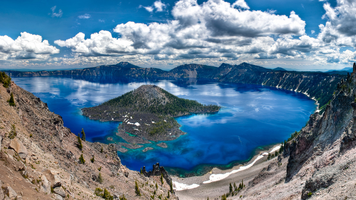 Stojąc na skalnym występie ponad pięć metrów nad powierzchnią oregońskiego Crater Lake zastanawiałem się, czy skok do wody przyniósłby mi siedem lat pecha… Pode mną przesuwały się białe chmury wokół odbitych w wodzie szczytów kaldery - to dlatego tafla jeziora nazywana jest Heaven’s Mirror (Zwierciadło Niebios). Kobaltowy błękit nieba odbity w wodzie był jeszcze bardziej intensywny niż w rzeczywistości.