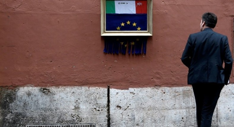 A man stares at a street-art installation in Rome inspired by Banksy and Italy's budget dispute with Brussels