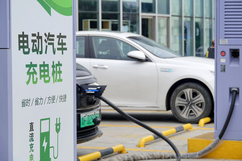 Samochód elektryczny ładowany na stacji ładowania we wschodniochińskiej prowincji Shandong, 22 sierpnia 2023 r.