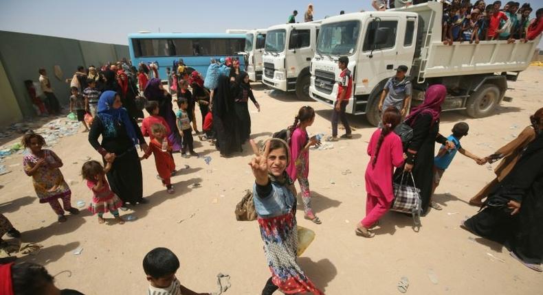 Iraqi civilians gather at a camp for displaced people after fleeing towns south of Mosul during fighting between Iraqi security forces and the Islamic State (IS) group 