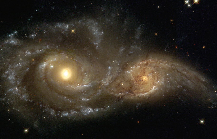 Zderzenie dwóch galaktyk spiralnych (NGC 2207 i IC 2163) wywołało zniekształcenie tej mniejszej. Zdjęcie z Kosmicznego Teleskopu Hubble’a.