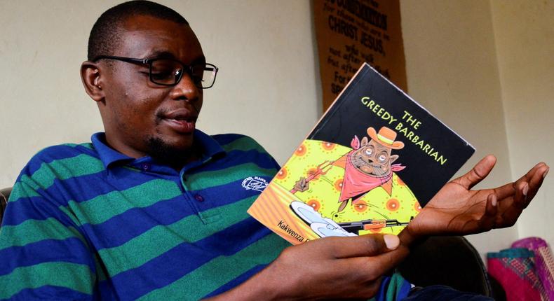 Kakwenza reading his book, The Greedy Barbarian. The book led to his arrest and alleged torture 