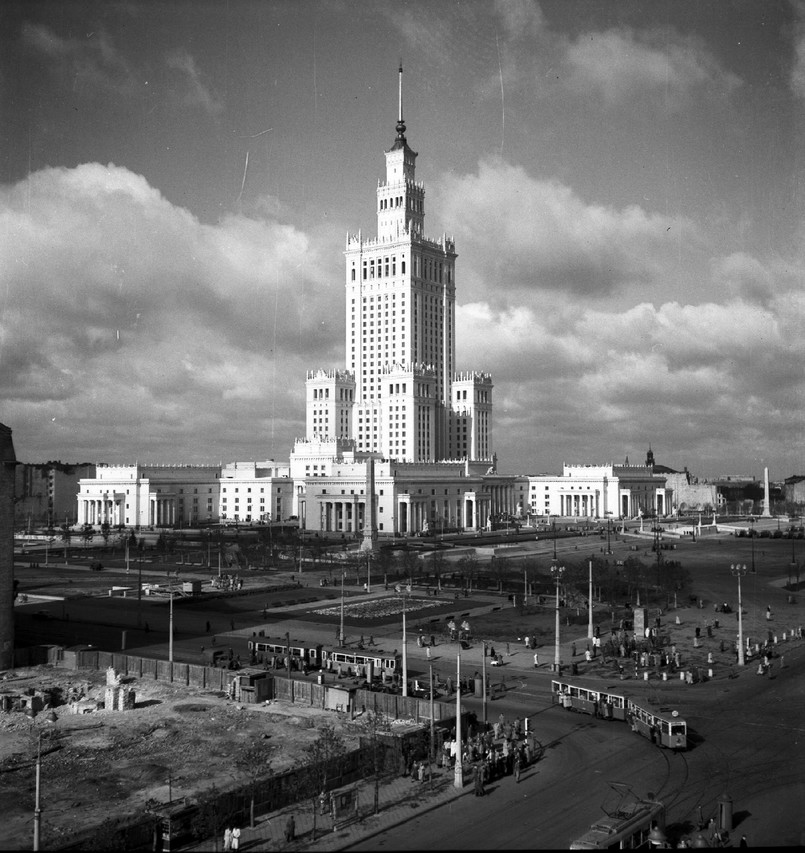 Wczoraj: Pałac Kultury i Nauki Pałac stanowił „dar narodu radzieckiego dla narodu polskiego”. Wybudowany w latach 1952–1955 według projektu radzieckiego architekta Lwa Rudniewa, budynek inspirowany jest moskiewskimi drapaczami chmur, które z kolei inspirowane są amerykańskimi wieżowcami art déco. Architektonicznie jest mieszanką socrealizmu i polskiego historyzmu. Na zdj.: Pałac Kultury i Nauki w Warszawie (1955–1956). Gmach od strony ulicy Marszałkowskiej. Na pierwszym planie widoczne skrzyżowanie z Alejami Jerozolimskimi. Autor: Siemaszko Zbyszko. Ze zbiorów Narodowego Archiwum Cyfrowego. www.nac.gov.pl