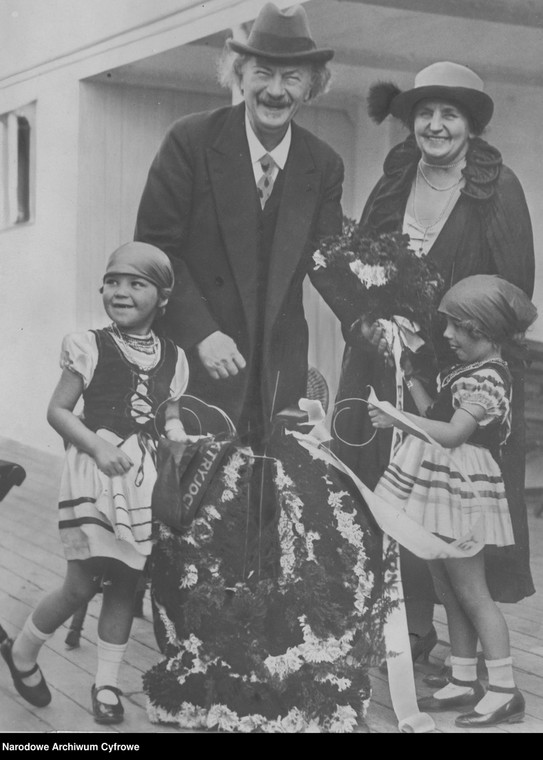  Ignacy Jan Paderewski z żoną Heleną. Na pierwszym planie widoczne dziewczynki w strojach ludowych trzymające wiązankę z kwiatów w 1927 r.