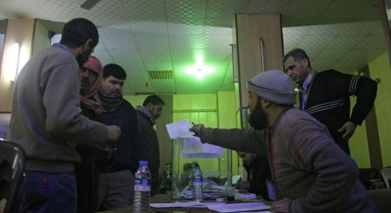 Syrian men queue to cast their vote at a polling station in the city of Idlib as they elect the city's first civilian council, two years after it was overrun by rebels and jihadists, on January 17, 2017