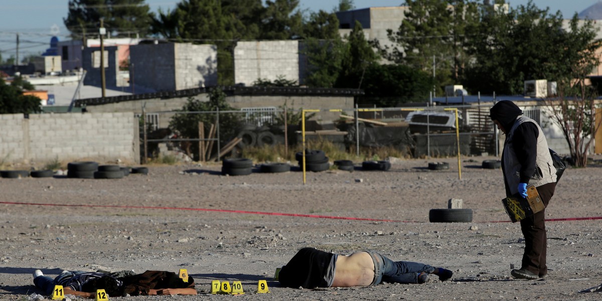 A forensic investigator at a crime scene where three men were killed by unknown assailants in Ciudad Juarez, Mexico, May 18, 2017.