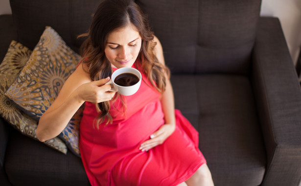 Kobieta w ciąży pije kawę