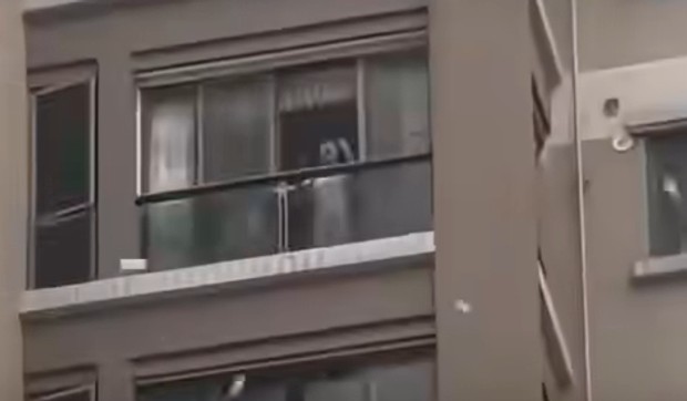 Bacila novac sa balkona zgrade