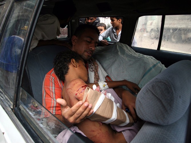 Mężczyzna wiozący ranne dziecko, po ataku oddziałów wojskowych lojalnych wobec prezydenta Jemenu Ali Abdullah Saleh. Taiz, Jemen, 2 listopada 2011