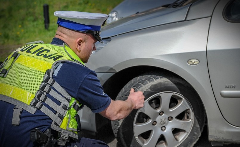 Policjant sprawdza stan opon