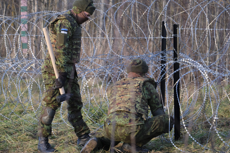 Rezerwiści Estońskich Sił Obronnych (EDF) instalują barierę z drutu kolczastego wzdłuż granicy estońskiej i rosyjskiej podczas krótkich ćwiczeń wojskowych w Meremae w Estonii, 20 listopada 2021 r.