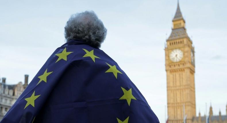 A protester draped in a European Union flag demonstrates outside the Houses of Parliament in London on March 13, 2017