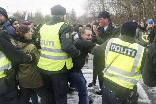 Police officers attempt to calm down people during a protest at the Danish-German border in Krusaa