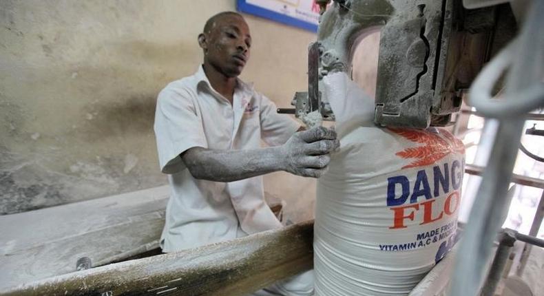 A worker operates a bag-sealing machine at the Dangote flour mill in Apapa district in Nigeria's commercial capital of Lagos November 13, 2010. REUTERS/Akintunde Akinleye