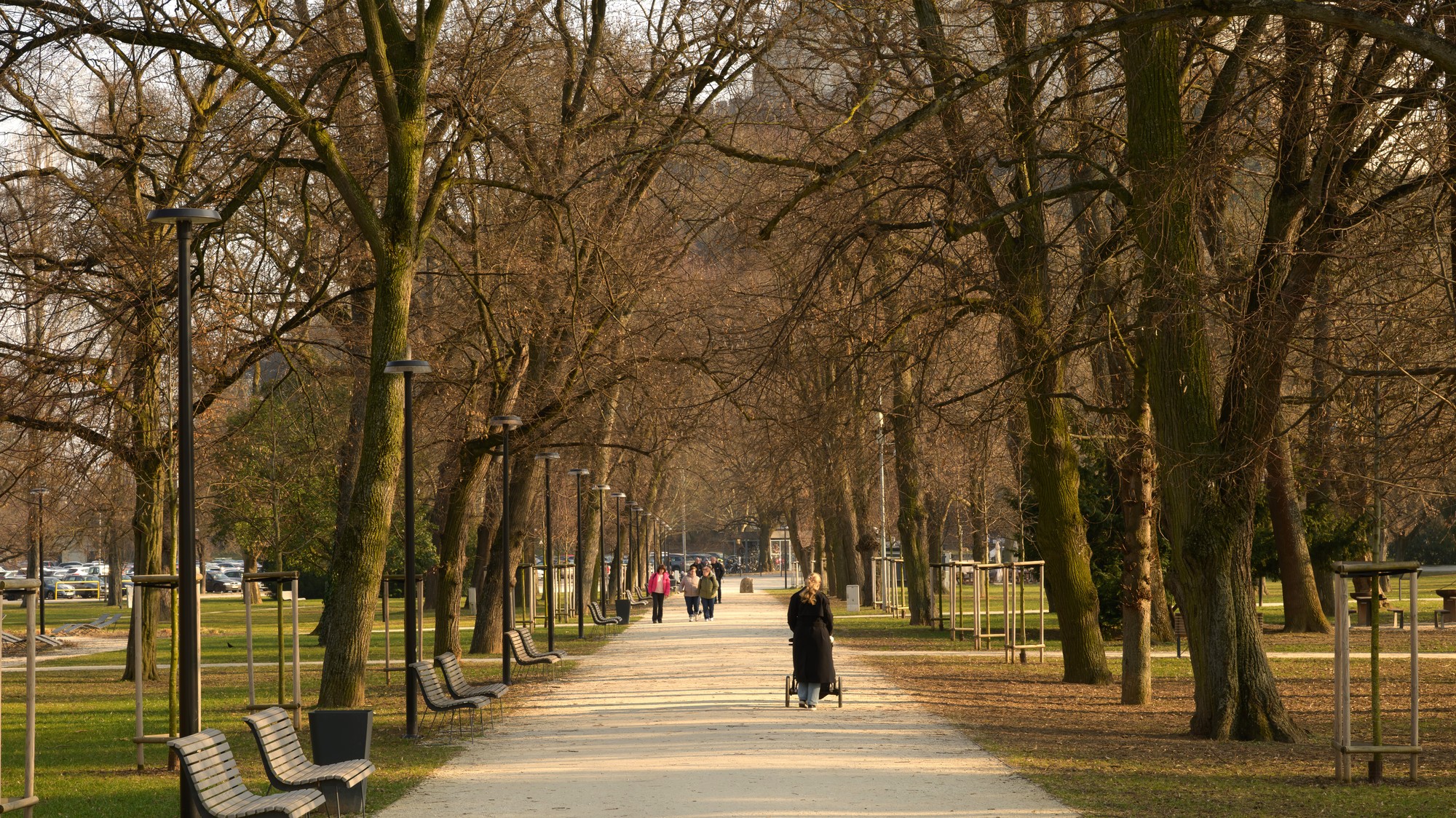 Ľudia sa prechádzajú v Mestskom parku v Nitre počas teplého marcového dňa