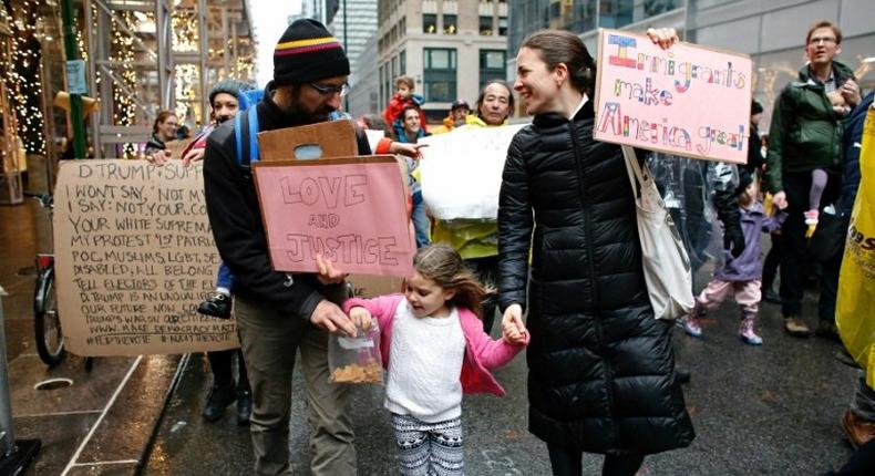 A family takes part in a protest march towards Trump Tower in New York to mark International Migrants Day