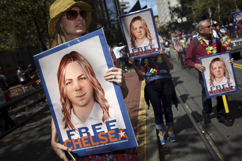 People with signs calling for the release of imprisoned Wikileaks whistleblower Chelsea Manning march in a gay-pride parade in San Francisco, June 28, 2015.