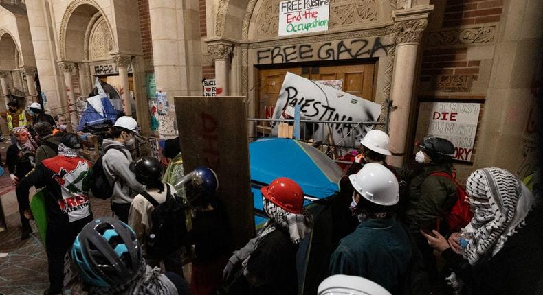 Protesters reinforce the barricades set up against one of the doors of Royce Hall as police started clearing a pro-Palestinian encampment on the campus of the University of California, Los Angeles.ETIENNE LAURENT/AFP via Getty Images