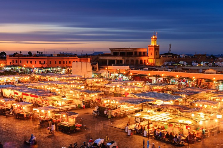 <strong>Marrakesz</strong> 
<br></br>
Marrakesz, zwany bramą do całego kraju, to dawne cesarskie miasto, które koniecznie trzeba zobaczyć. W latach sześćdziesiątych była to prawdziwa hipisowska mekka dla artystów takich jak Andy Warhol, Alfred Hitchcock nakręcił tu sceny do „Człowieka, który wiedział za dużo”, była tu Rita Hayworth, lądował nawet odrzutowiec z The Beatles i Rolling Stones, którzy spacerowali po labiryntowych uliczkach średniowiecznej medyny i cieszyli się odpoczynkiem. Dziś Marrakesz uznawany jest za kwintesencję Maroka. Warto zagłębić się pomiędzy czerwone mury, a także poznać pustynię i góry poza miastem. Każda chwila spędzona w tym miejscu, z pewnością zapisze się w naszej pamięci, jako jedna z tych niezapomnianych.
<br></br>
Największa atrakcja miasta to główny plac medyny – Dżami al-Fana. Doceniony przez UNESCO, wibrujący życiem rynek, ożywa o zmierzchu, zamieniając się w olśniewającą scenę rozrywkową. Egzotyczni uliczni artyści, muzycy, tancerze, nawołujący sprzedawcy, tatuatorzy, a nawet zaklinacze węży – znaleźć tu można wszystko. Plac jest ogromny i zatłoczony. Bez problemu znajdziemy jednak miejsce, w którym spróbować można tradycyjnych potraw. Kuchnia i uliczne jedzenie to bowiem kolejny ze znaków rozpoznawczych Dżami al-Fana. Najważniejszym punktem orientacyjnym na placu jest Meczet Koutoubia, przez wielu uważany za najpiękniejszy i najbardziej proporcjonalny meczet na świecie. Ukończony został za czasów panowania dynastii Almohadów, Kalifaakuba al-Mansura (1184-1199). Kiedyś przed jego wejściem swoje stragany rozstawiali sprzedawcy rękopisów, dlatego nawet w literaturze Meczet Koutoubia jest często określany jako 