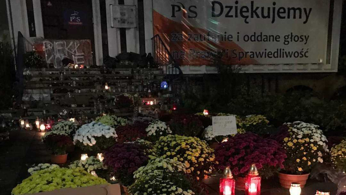 Chryzantemy i znicze przed siedzibą PiS w Szczecinie