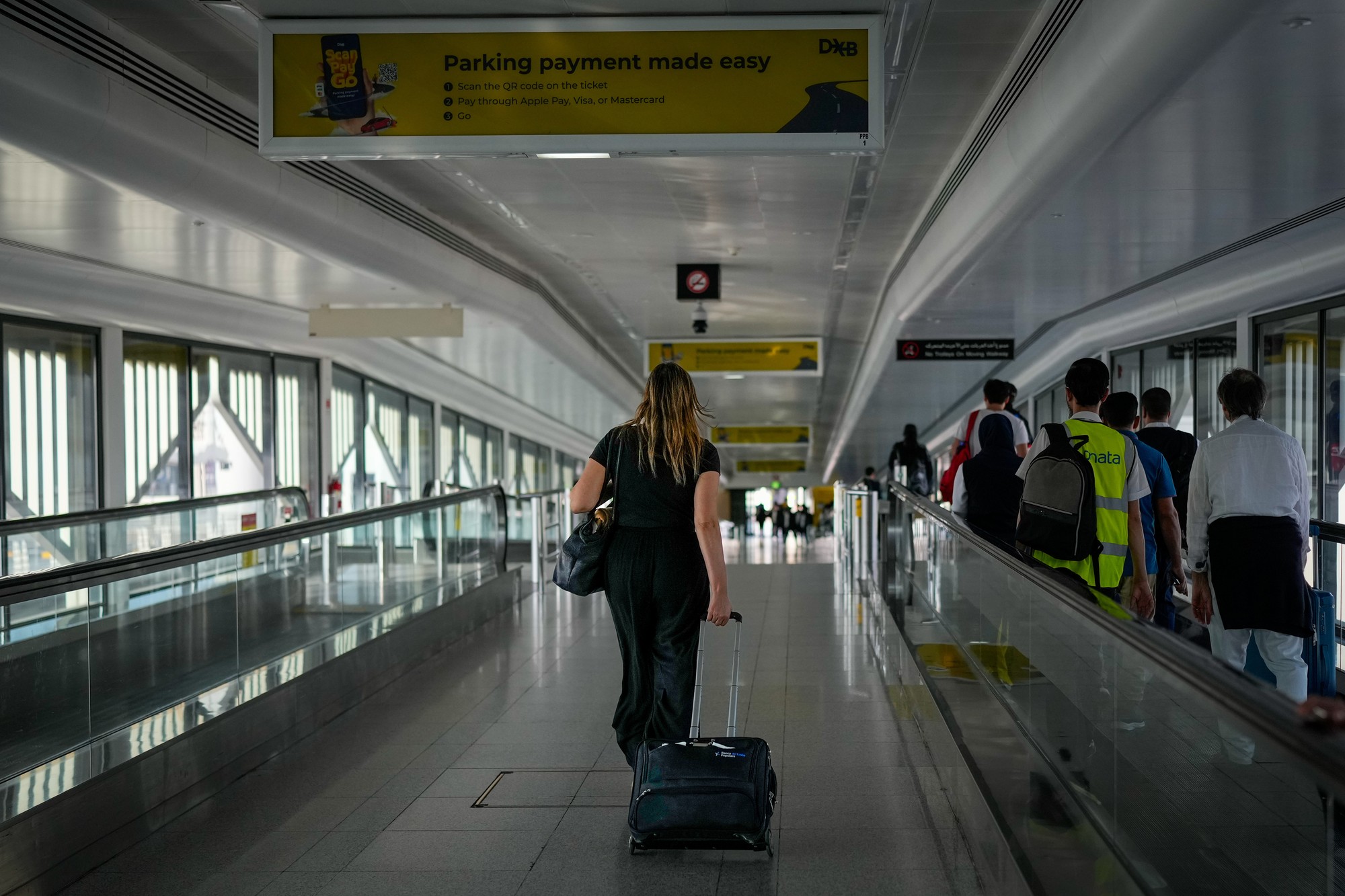 Pasažierka kráča na medzinárdnom letisku v Dubaji 5. marca 2026 po tom, ako letisko limitovalo vypravenie letov v rámci operatívnych obmedzení pre pokračujúce odvetné útoky Iránu.