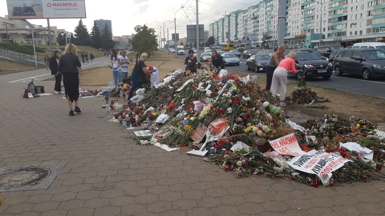 Sprzątanie kwiatów w miejscu śmierci demonstranta w Mińsku.