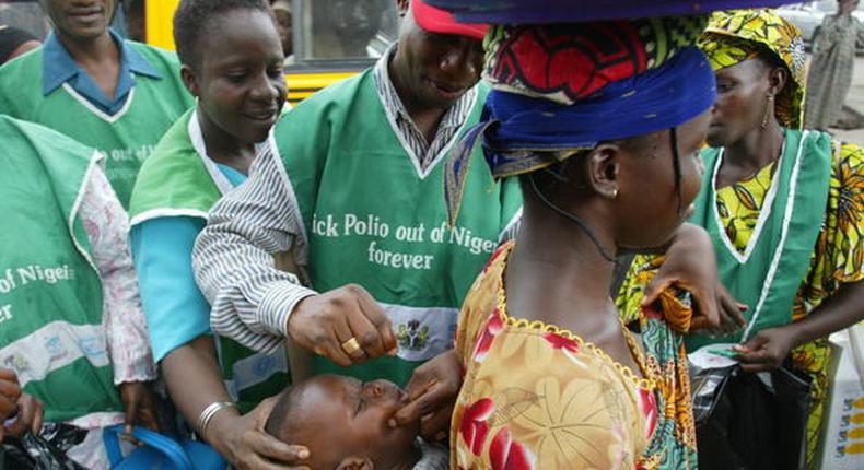 Health officers administering vaccine to infants during immunisation exercise in Nigeria