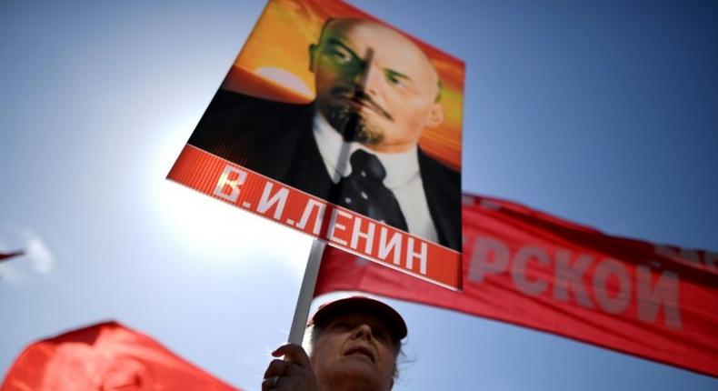 A Russian Communist party activist carries a banner with a portrait of late Soviet leader Vladimir Lenin during a May Day rally in central Moscow on May 1, 2017