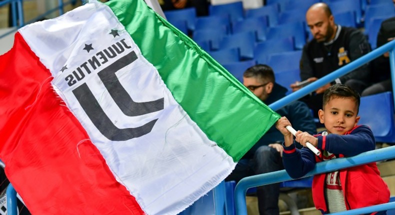 A young Juventus supporter waves the Italian flag.