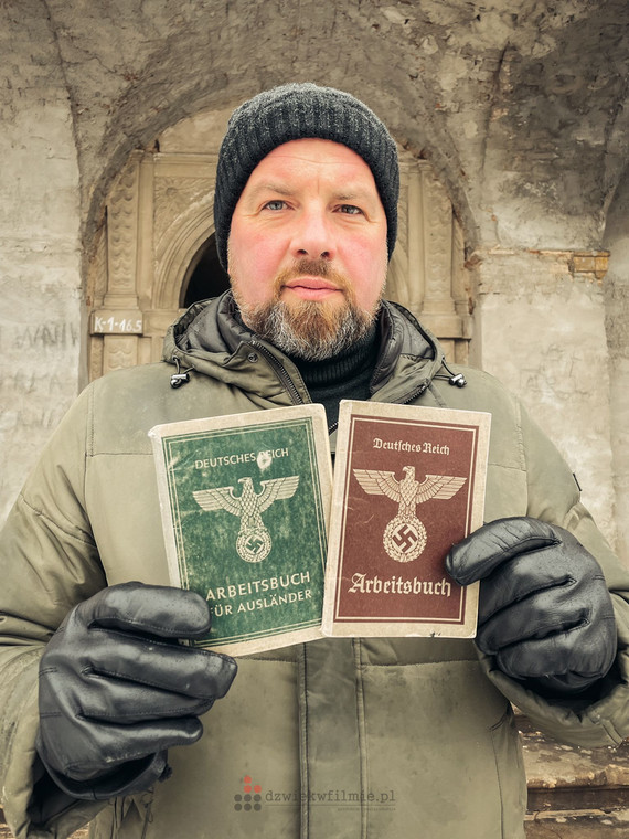 Łukasz Kazek pokazuje tzw. książeczki pracy robotników przymusowych z czasu II wojny światowej. Zielona należała do Polaka z Garwolina.