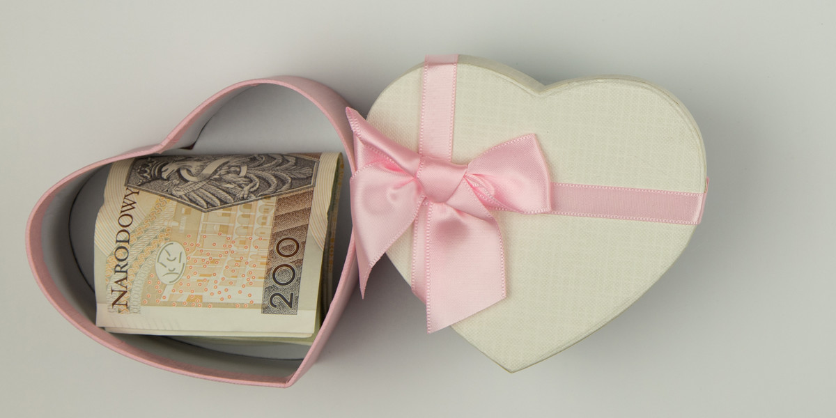 banknotes of polish zloty in a box in the shape of a heart, white background isolated object