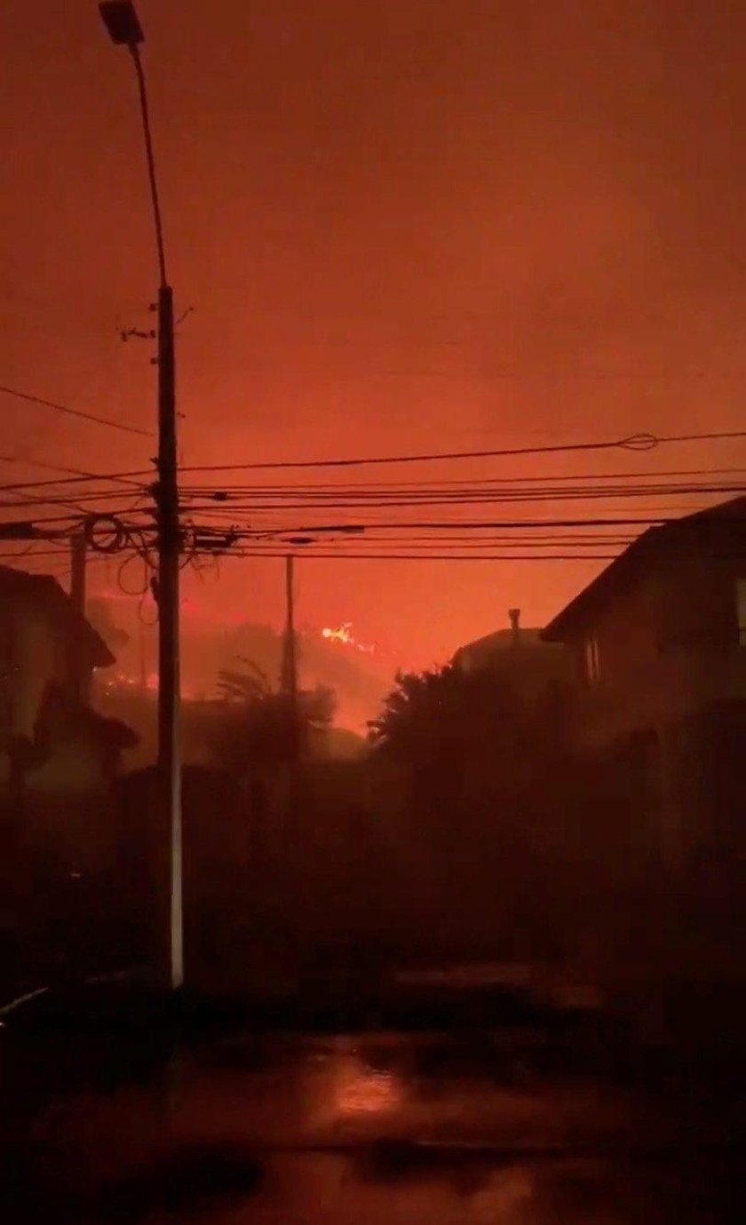 A sky glows red from a nearby fire from San Pedro de la Paz, Concepcion