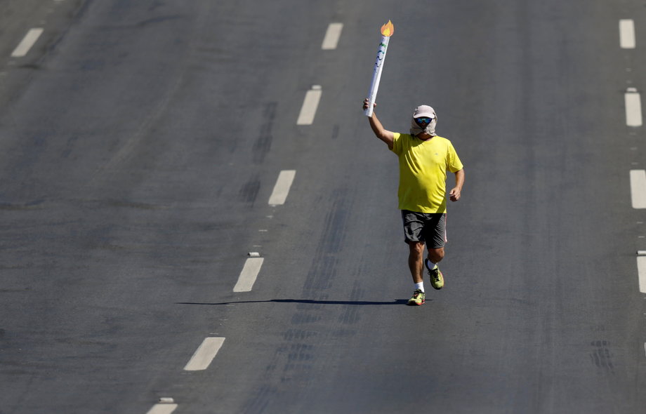 A man carries a fake torch during the Olympic Flame torch relay in Brasilia, Brazil.