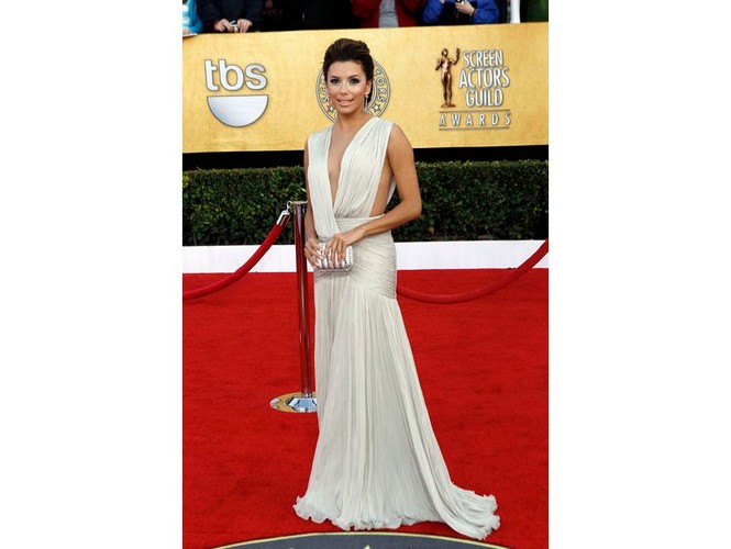 Eva Longoria nie boi się głębokich dekoltów.  Tu w białej kreacji od Georges Hobeika Couture z najnowszej wiosennej kolekcji. Do tego minimalizm dodatków: srebrna torebka Ferragamo i kolczyki od Freda Leightona