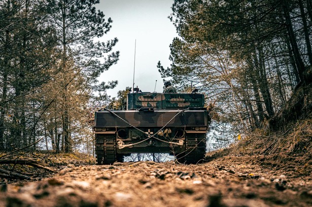 Czołg Leopard 2PL w trakcie ćwiczeń. Czarny napis "Wales" znajduje się z tyłu wieży czołgu.