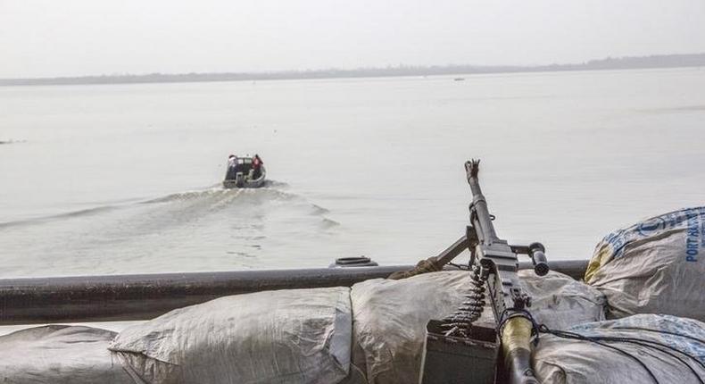 A machine gun is seen on a sandbag on a boat off the Atlantic coast in Nigeria's Bayelsa state December 19, 2013. REUTERS/Stringer