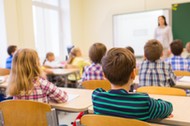 group of school kids and teacher in classroom