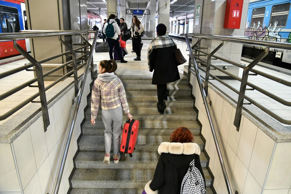 Putnici nose prtljag uz stepenište